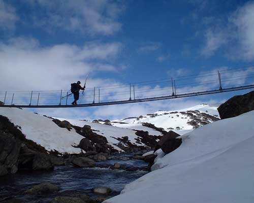Person walking across a suspension bridge over the Snowy River